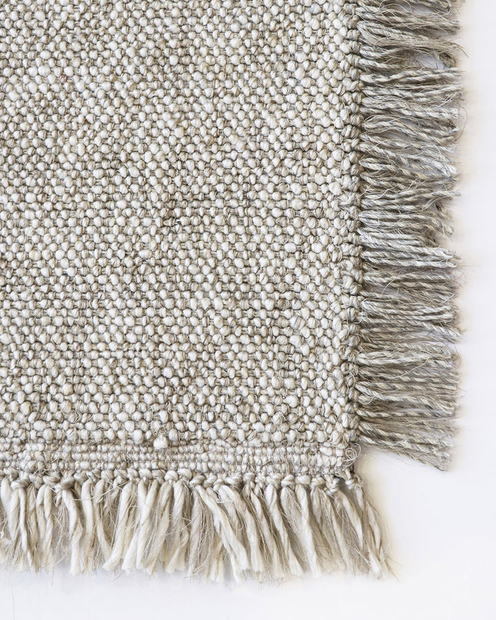 Ulster Floor Rug Create a casual yet refined interior with the subtle texture of the Ulster. Wool and linen fibres are handwoven in a classic 1-1 structure, which are blended in a contemporary monochrome colourway. Two-tone fringing finishes the design, s