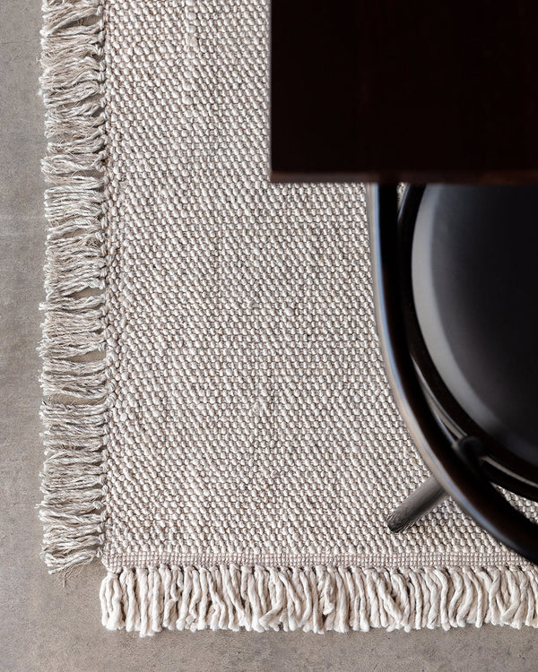 Ulster Floor Rug Create a casual yet refined interior with the subtle texture of the Ulster. Wool and linen fibres are handwoven in a classic 1-1 structure, which are blended in a contemporary monochrome colourway. Two-tone fringing finishes the design, s