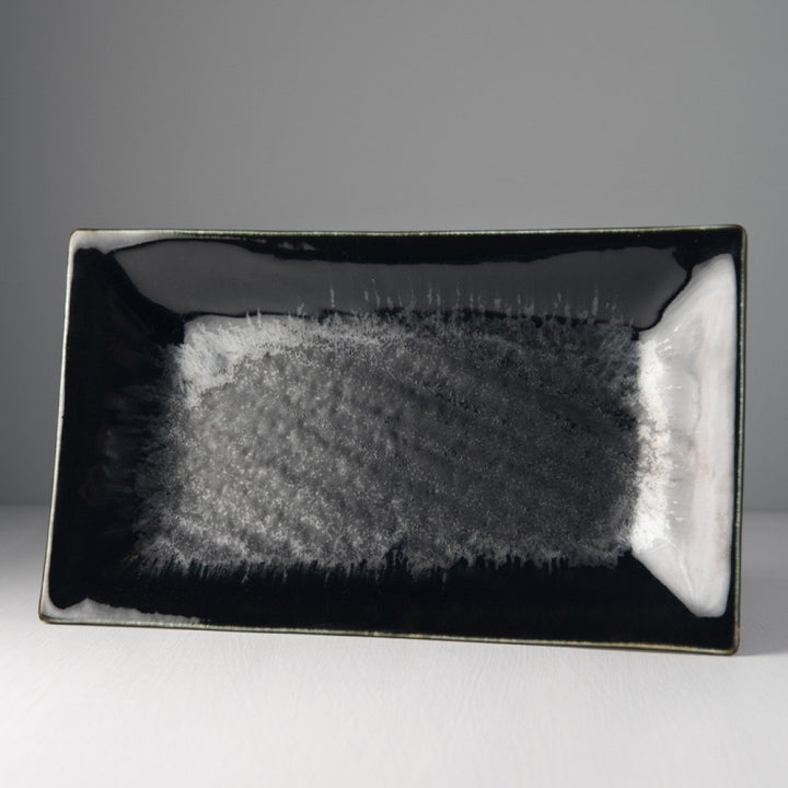 Save on Matte Black with Shiny Edge Rectangle Platter Made in Japan at BEON. 33cm long x 19cm wide Rectangle platter in Matte Black with Shiny Edge design. A silvered matte black body, the edge hand-dipped in a rich glossy black. A subtle play of blue and green accents are hidden within the pooling of the glaze. Beautiful serving platter to present a wide variety of dishes, use for salads, rice dishes and meats. All food will look beautiful against the black glaze on this platter. Handcrafted in JapanMicrow