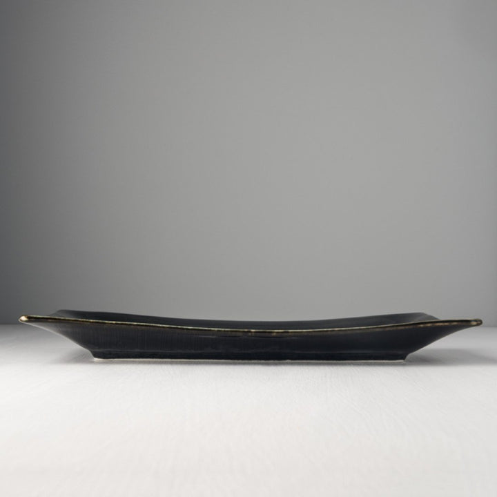 Save on Matte Black with Shiny Edge Rectangle Platter Made in Japan at BEON. 33cm long x 19cm wide Rectangle platter in Matte Black with Shiny Edge design. A silvered matte black body, the edge hand-dipped in a rich glossy black. A subtle play of blue and green accents are hidden within the pooling of the glaze. Beautiful serving platter to present a wide variety of dishes, use for salads, rice dishes and meats. All food will look beautiful against the black glaze on this platter. Handcrafted in JapanMicrow