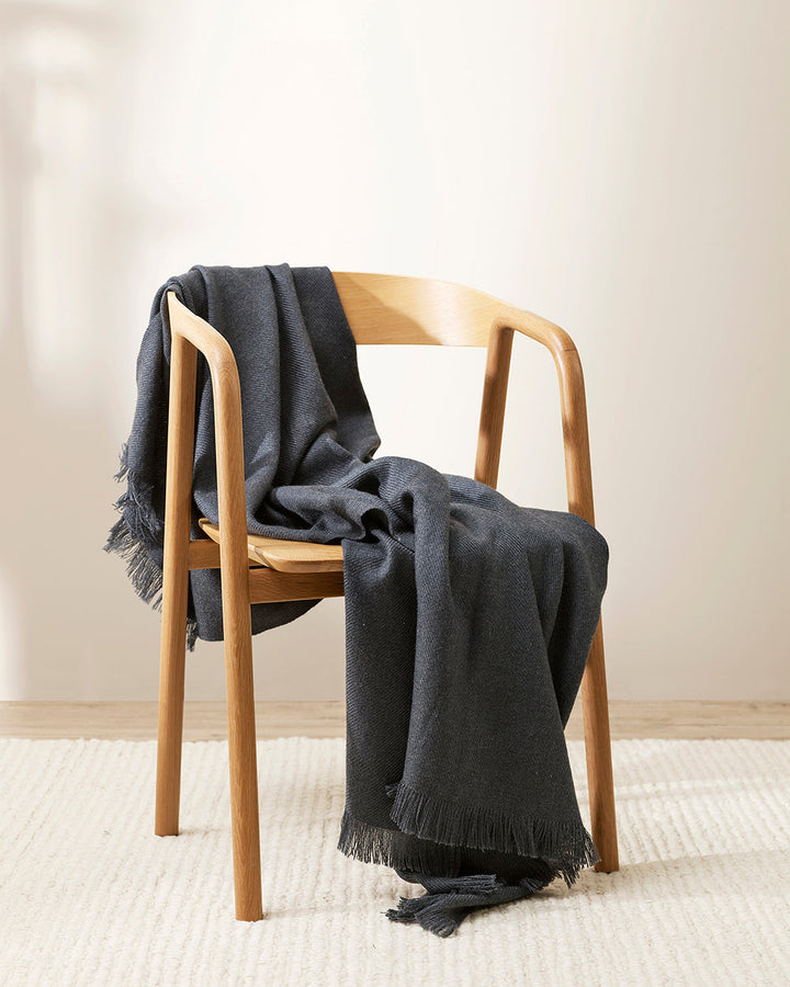 Altona Throw Add a pared-back accent to your space with the lightweight softness of Altona. Finely woven from a blend of wool and recycled polyester, the solid colour and delicate fringe edge makes this piece easy to style into most interior schemes. The