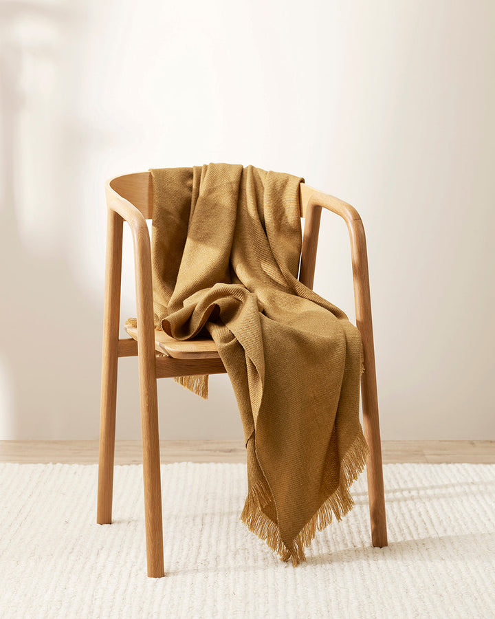 Altona Throw Add a pared-back accent to your space with the lightweight softness of Altona. Finely woven from a blend of wool and recycled polyester, the solid colour and delicate fringe edge makes this piece easy to style into most interior schemes. The