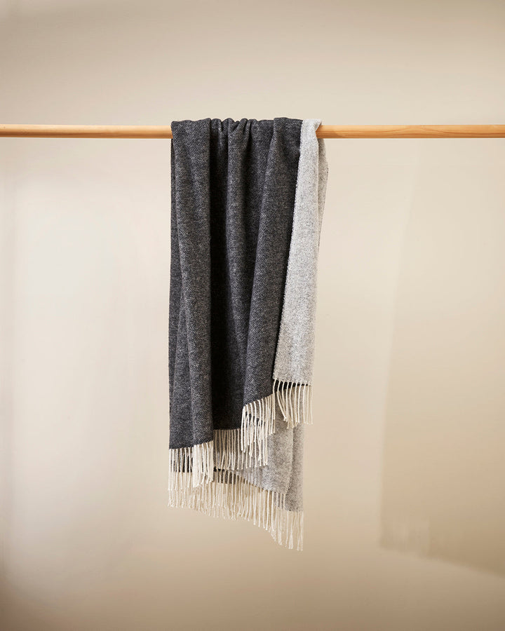 Casa Throw Beautifully soft and lightweight, the Casa adds an unparallel sense of timeless luxury to a space. Woven in a two-tone, reversible design, the merino composition feels inviting and cocoon-like, while the warm charcoal tone adds a gentle contras
