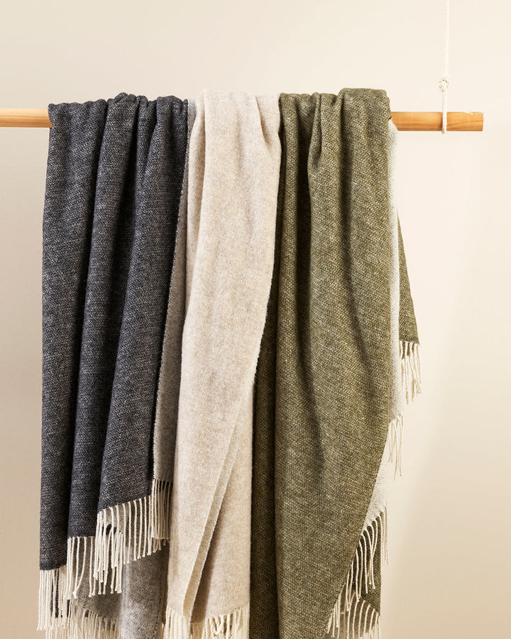 Casa Throw Beautifully soft and lightweight, the Casa adds an unparallel sense of timeless luxury to a space. Woven in a two-tone, reversible design, the merino composition feels inviting and cocoon-like, while the warm charcoal tone adds a gentle contras