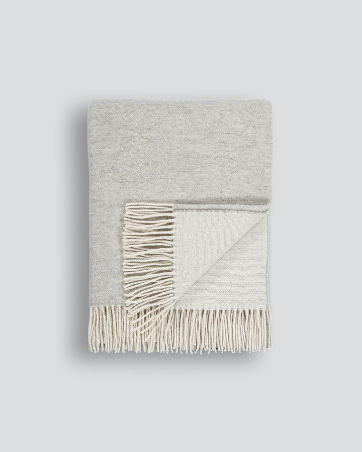 Casa Throw Beautifully soft and lightweight, the Casa adds an unparallel sense of timeless luxury to a space. Woven in a two-tone, reversible design, the merino composition feels inviting and cocoon-like, while the warm charcoal tone adds a gentle contras