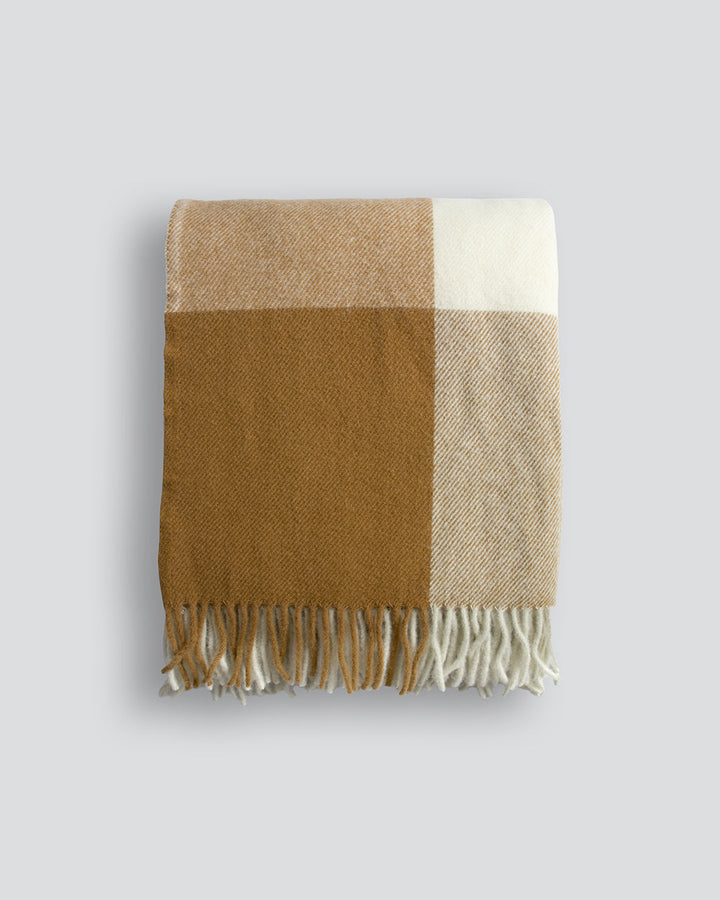 Gladstone Throw Featuring an off-set plaid design, a modern take on country style is celebrated in this luxurious, pure wool throw. Locally crafted from wool grown in the Hawkeâ€™s Bay, the timeless design and natural ochre tones create a reassuring sense