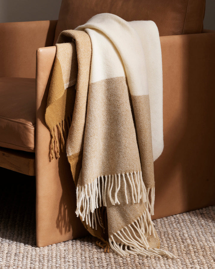 Gladstone Throw Featuring an off-set plaid design, a modern take on country style is celebrated in this luxurious, pure wool throw. Locally crafted from wool grown in the Hawkeâ€™s Bay, the timeless design and natural ochre tones create a reassuring sense