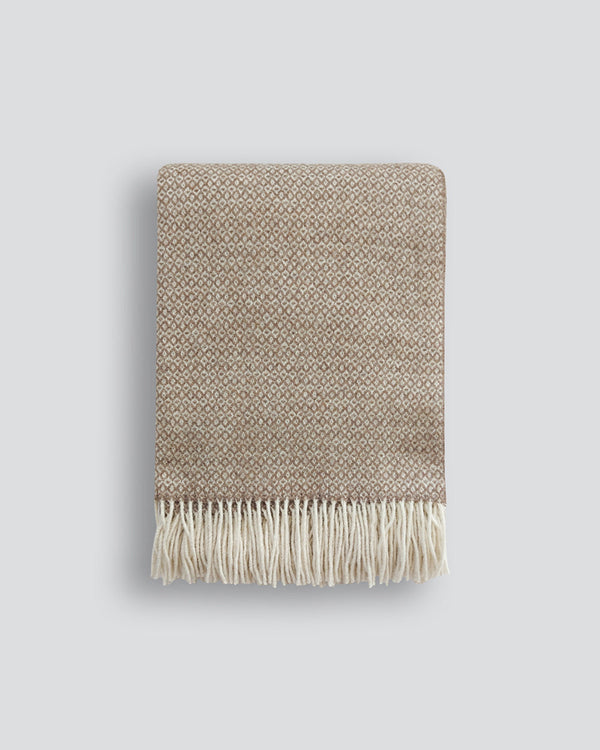 Littano Throw Crafted from a merino wool blend, this luxuriously soft throw offers a wonderful sense of warmth and comfort. Featuring a small diamond motif and fringe detailing, this light ochre colourway is a refined addition to any space. Australian Sto