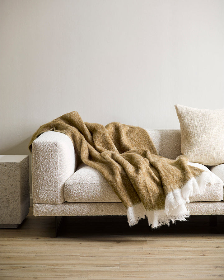 Sorrento Throw Enhance the warmth and comfort of your living space with the sumptuous addition of our Sorrento throw. Reminiscent of mohair, the brushed wool texture feels inviting and cocoon-like, while the earthy turmeric tone adds a touch of colour to